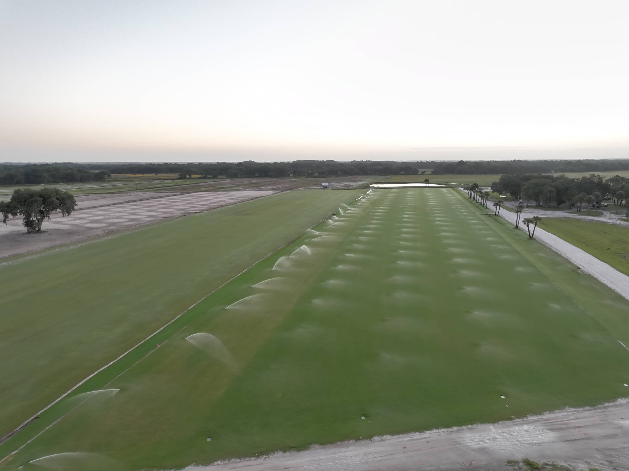 Aerial view of irrigated sod fields with the onsite retention pond in the distance